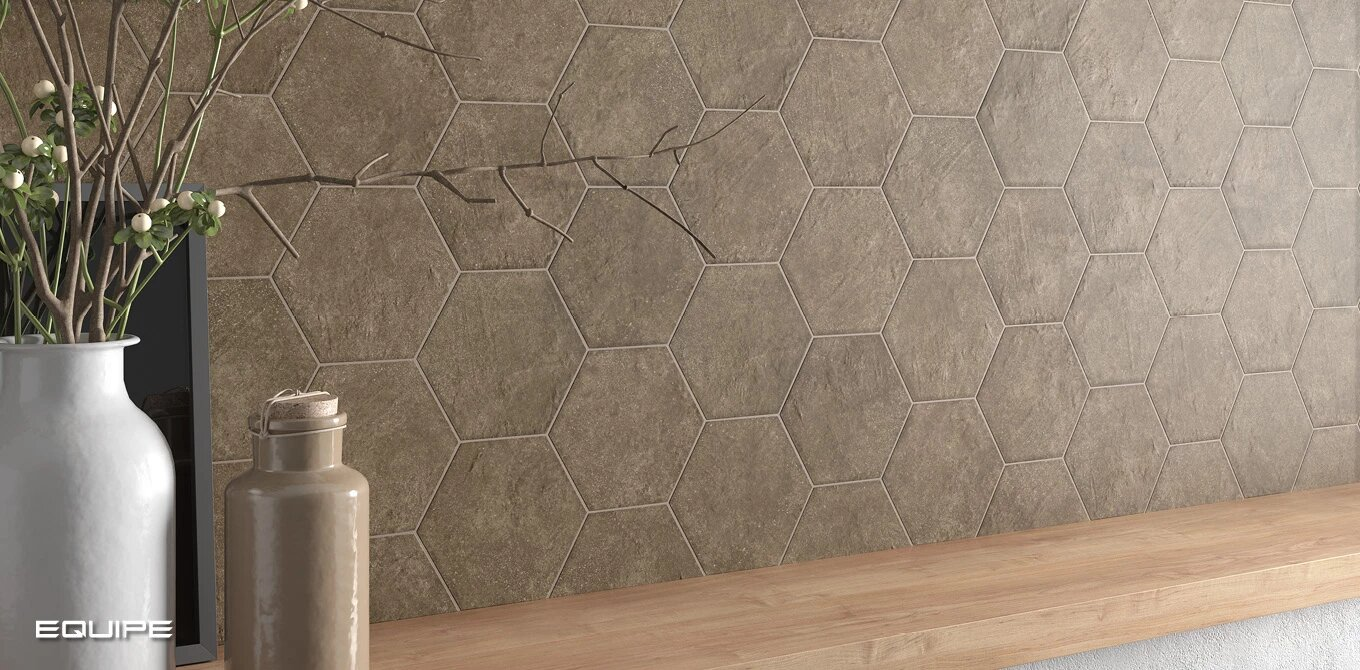 Carrelage aspect ciment couleur anthracite avec motifs géométriques 17.5x20 cm sur un mur intérieur avec mobilier en bois clair et décoration florale blanche