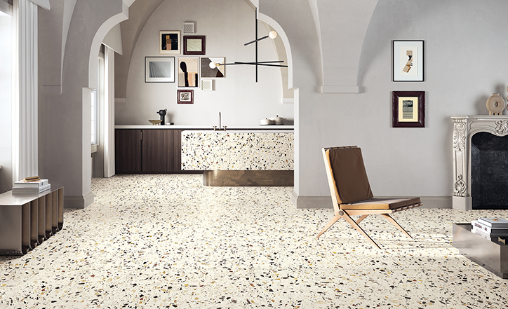 Carrelage Terrazzo multicouleur avec éclats de couleur variés 60x60 cm dans une cuisine moderne blanche avec meubles en bois et îlot central