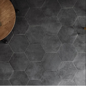 Carrelage aspect pierre noir hexagonal sur une surface avec pied de table en bois