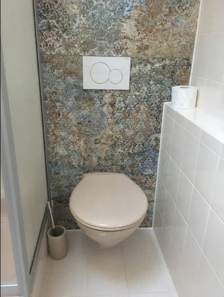 Carrelage aspect tissu beige nuances de gris et bleu 50x100 cm dans une salle de bain blanche avec toilette et accessoires coordonnés