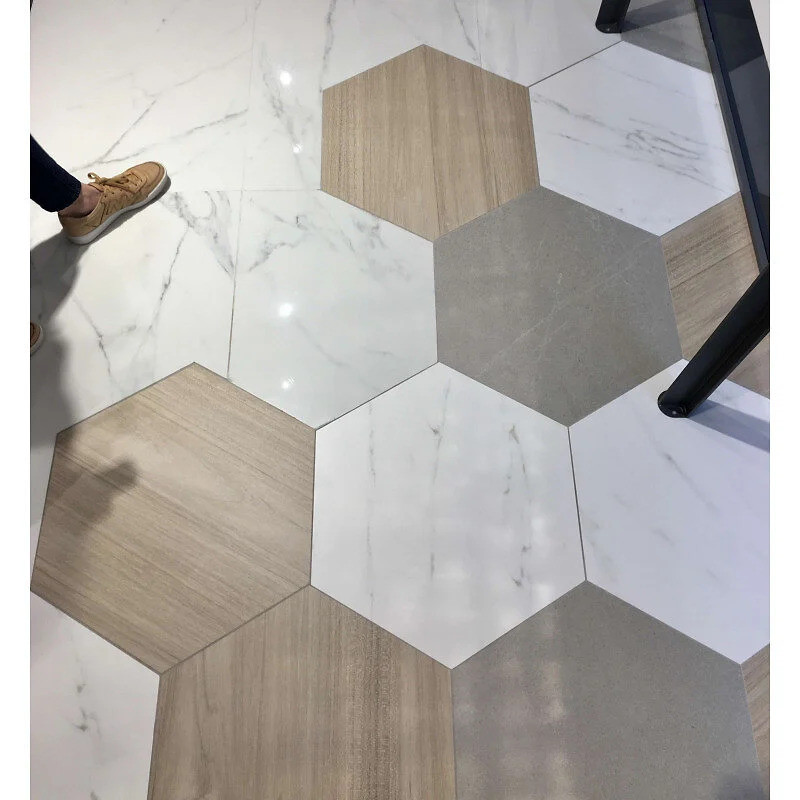 Carrelage marbre blanc avec veines grises hexagonal 60x60 cm dans un espace intérieur au sol clair et mobilier moderne