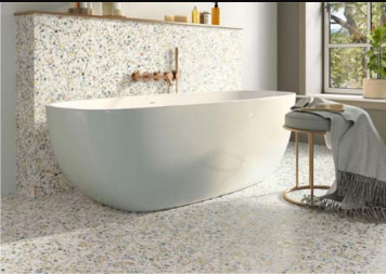 Carrelage Terrazzo multicouleur 60x60 cm dans salle de bain blanche avec baignoire ovale et accessoires en bois