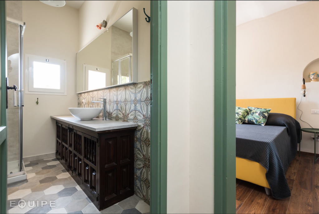 Carreau de ciment terracotta avec motifs géométriques 20x20 cm dans une salle de bain couleurs crème et bois avec meuble vasque et miroir