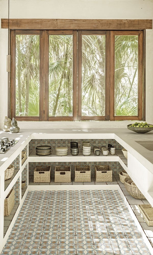 Carreau de ciment multicouleur avec motifs géométriques 20x20 cm dans une cuisine beige avec étagères blanches et accessoires en osier