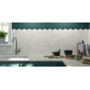 Carrelage uni blanc dans une cuisine moderne avec comptoir en granit, accessoires de cuisine en inox et plantes sur le rebord de