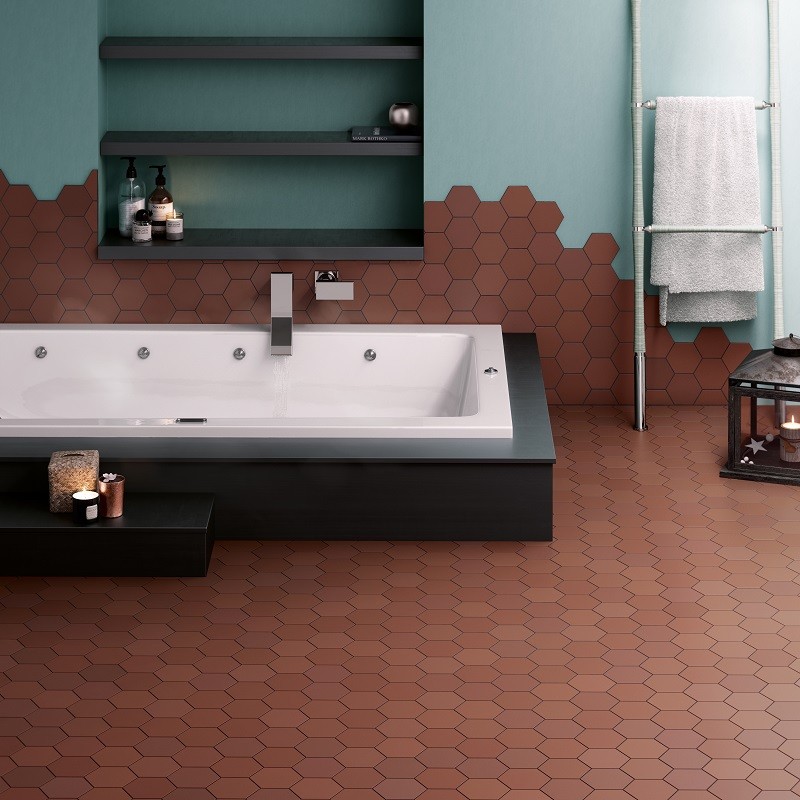 Carrelage uni marron hexagonal dans salle de bain teal avec baignoire blanche et étagère murale noire