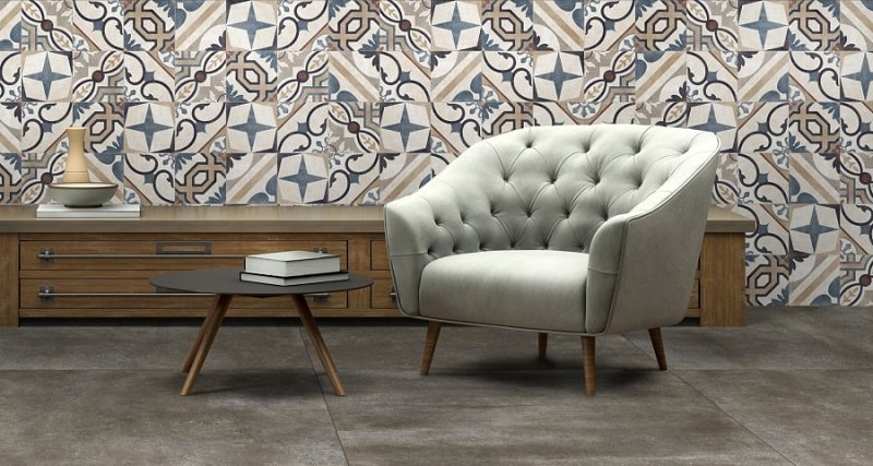 Carreau de ciment multicouleur motifs géométriques et floraux 20x20 cm dans un salon avec parquet gris fauteuil beige table basse et meuble bois