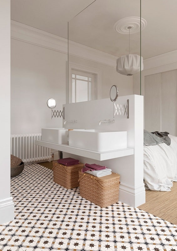 Carreau de ciment or et noir 30x30 cm avec motifs dans une salle de bain aux murs blancs, paniers en osier et serviettes colorées.