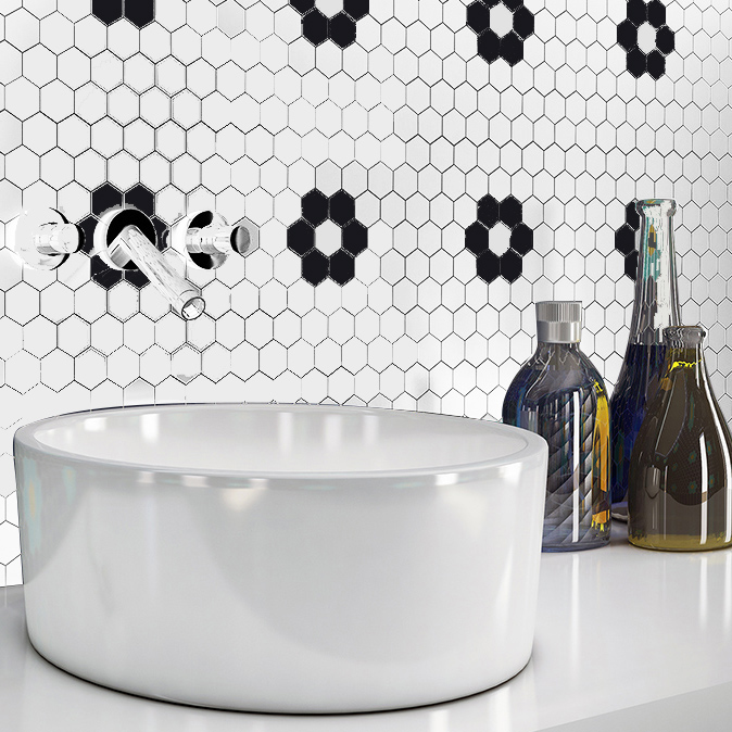 Carrelage noir et blanc hexagonal motifs géométriques dans une salle de bain moderne avec lavabo blanc et accessoires décoratifs