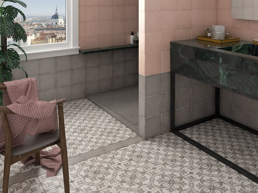 Carreau de ciment gris avec motifs floraux 20x20 cm dans une salle de bain tons pastel, meubles en marbre vert, fauteuil et accessoires roses