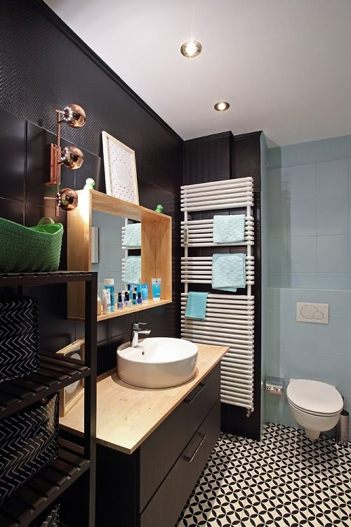 Carreau de ciment noir et blanc motifs géométriques 30x30 cm dans une salle de bain aux murs bleu clair et accessoires turquoise