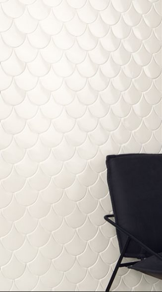 Carrelage uni blanc effet écailles sur une partie de mur visible à côté dune chaise noire élégante