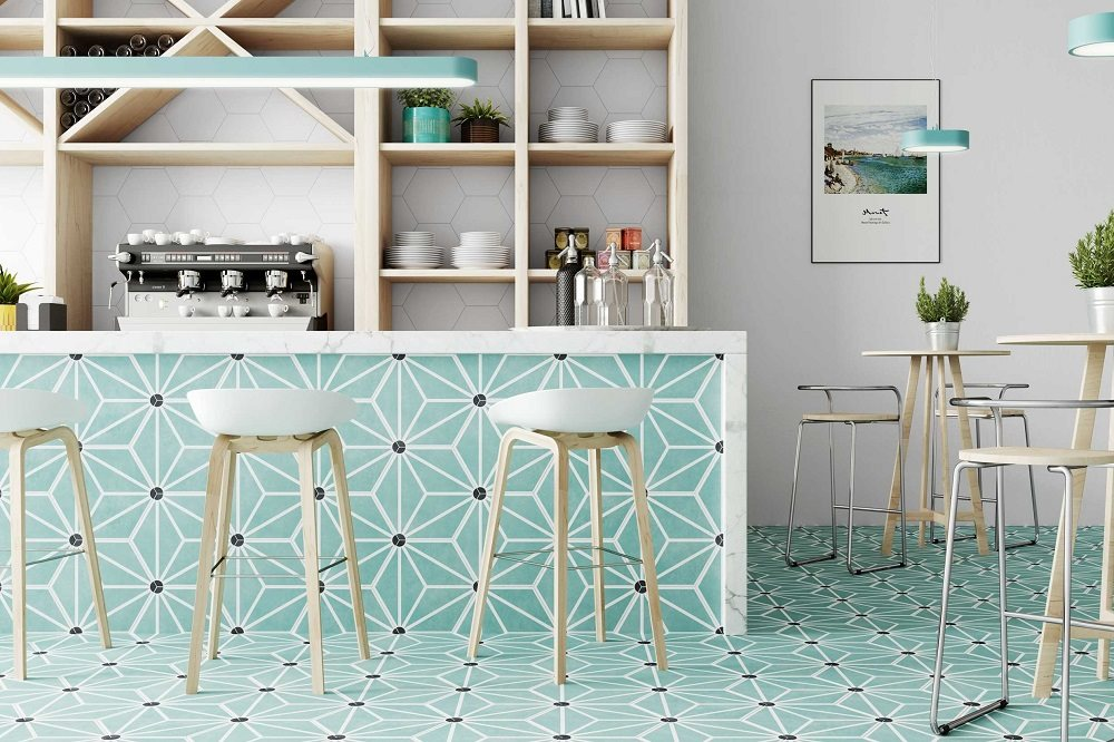 Carreau de ciment vert à motifs géométriques sur une cuisine moderne avec meubles blancs et étagères en bois