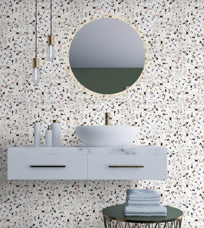 Carrelage Terrazzo blanc avec touches noir gris marron 20x20 cm dans une salle de bain tons gris meuble vasque moderne miroir rond luminaire élégant