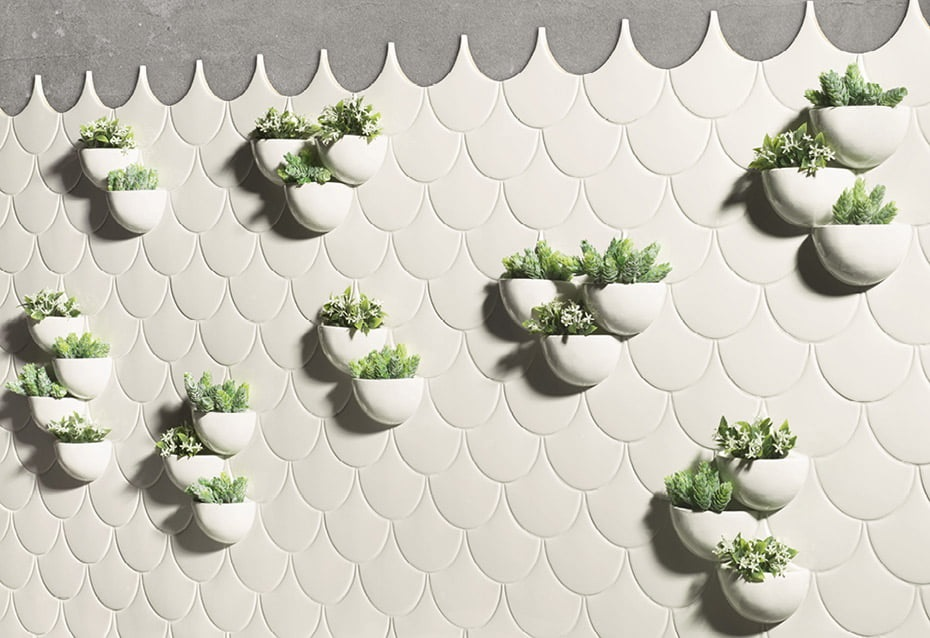Carrelage uni blanc écailles 12,7X6,2 sur mur avec pots de plantes vertes accrochés