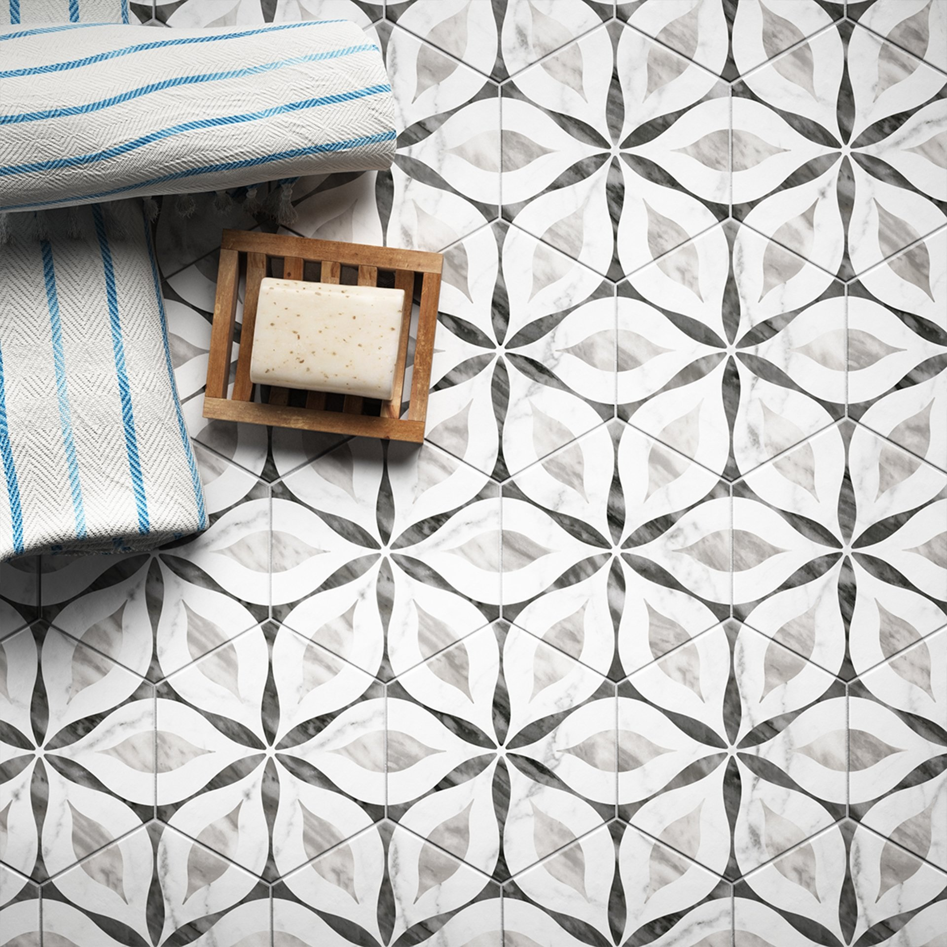 Carreau de ciment gris et blanc motifs géométriques dans une salle de bain épurée avec serviette bleue et porte-savon en bois