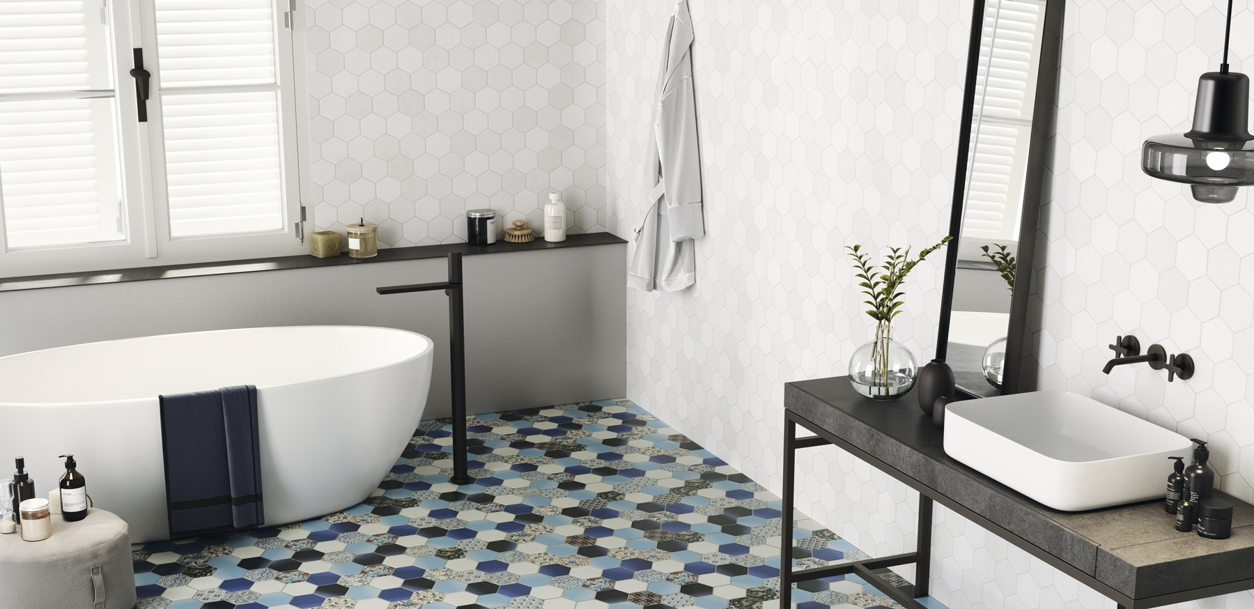 Carrelage uni blanc dans une salle de bain épurée, sur sol à motif géométrique bleu, avec baignoire blanche, étagère noire et accessoires déco
