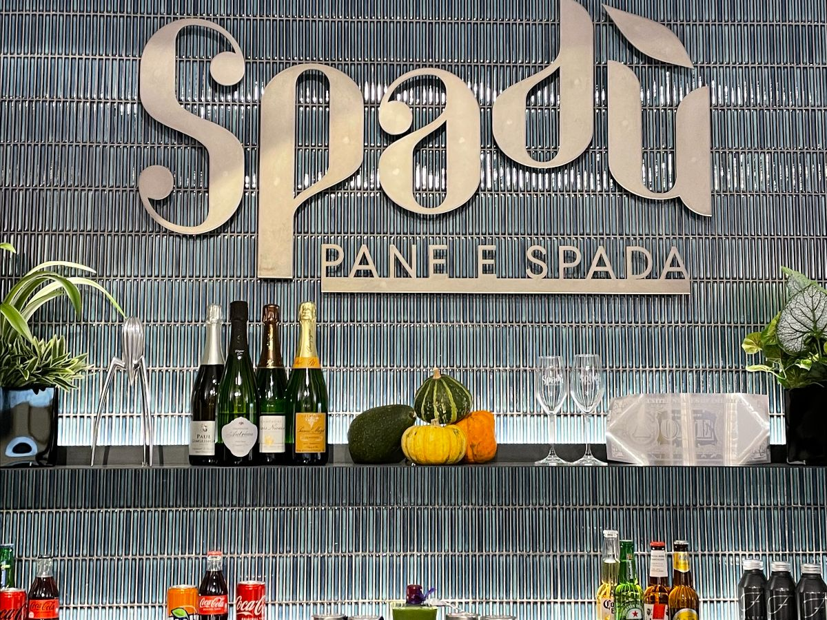 Carrelage uni bleu dans un bar avec des bouteilles et verres sur étagères en fond