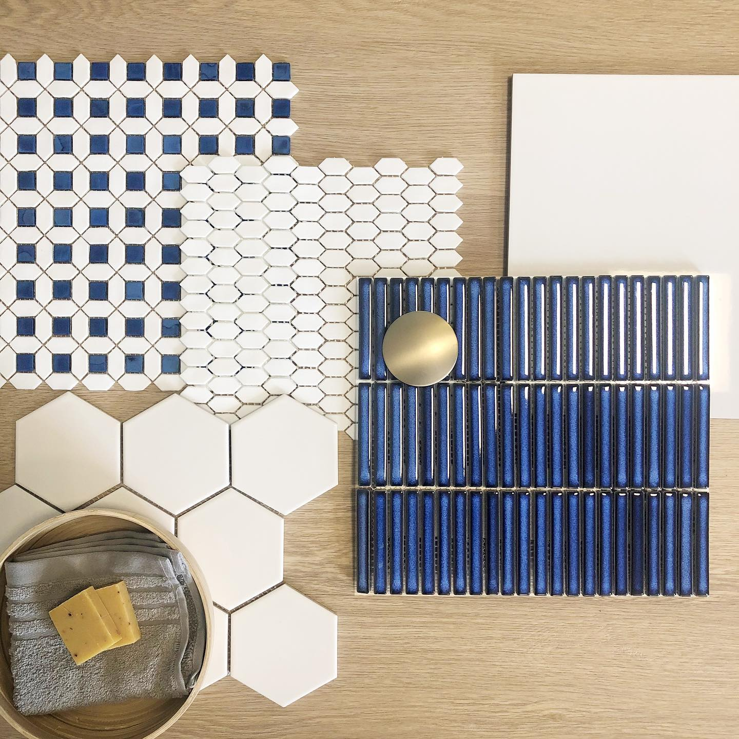 Carrelage uni blanc et bleu, hexagones et rectangles, présentation sur bois avec accessoires