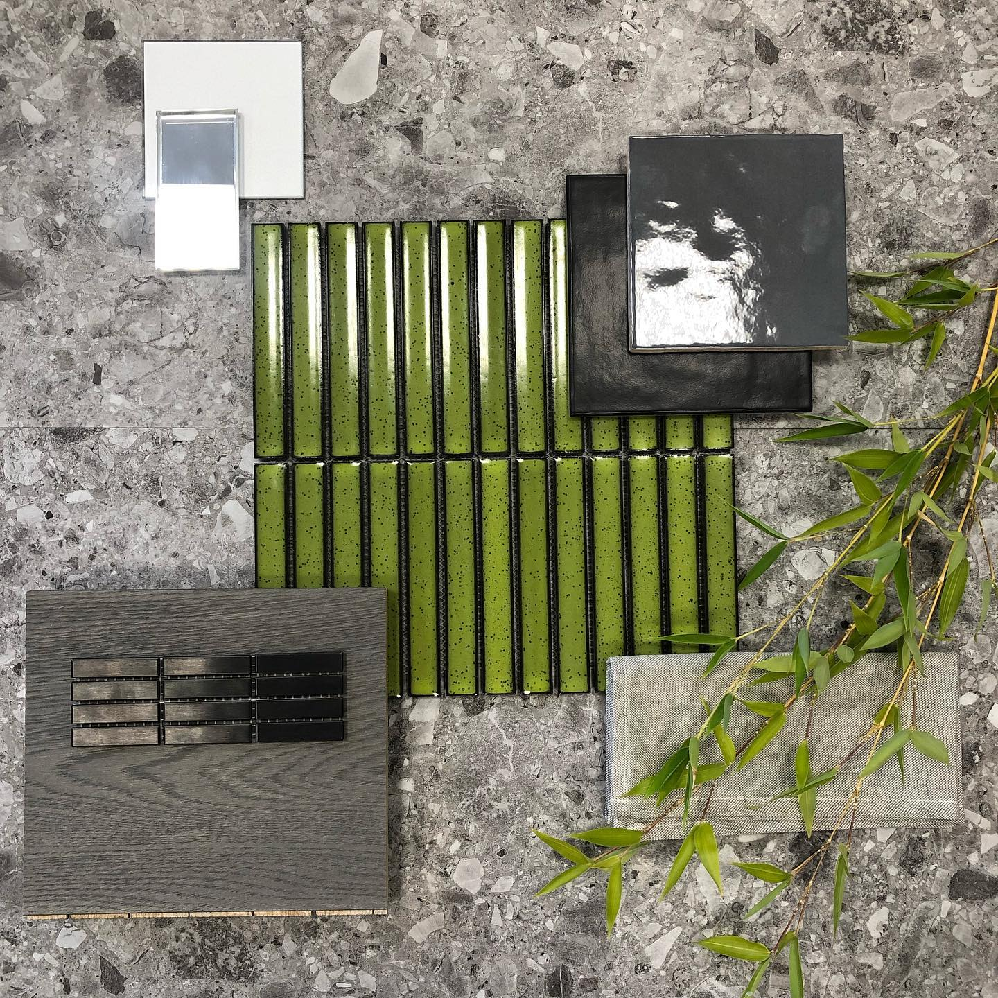 Carrelage uni vert, noir et gris, échantillons et nuances variées sur fond texturé avec feuillage vert