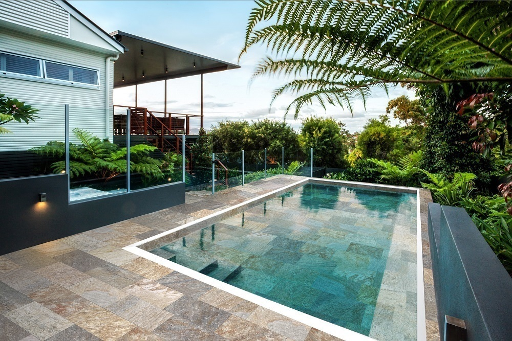 Carrelage effet pierre marron nuances de beige 30x60 cm sur terrasse extérieure verdure et piscine