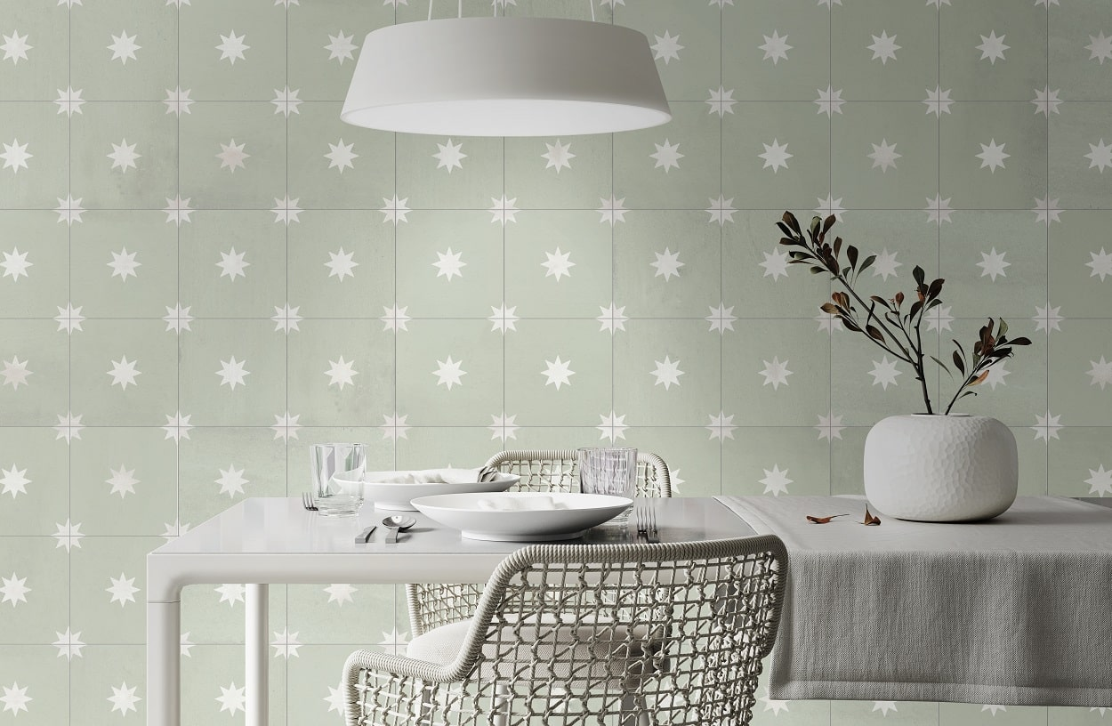 Carreau de ciment vert à motif étoile blanc sur table blanche dans salle à manger tons pastel avec chaise design et suspension moderne