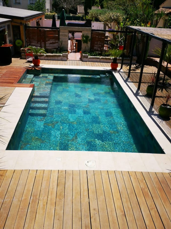 Carrelage de terrasse en bois avec piscine naturelle style pierre