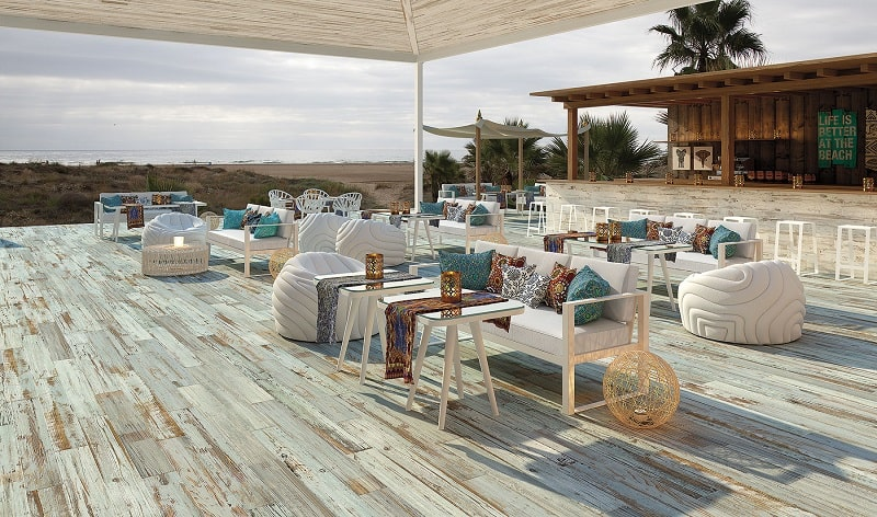 Un restaurant sur une terrasse avec du carrelage imitation bois blanc au sol